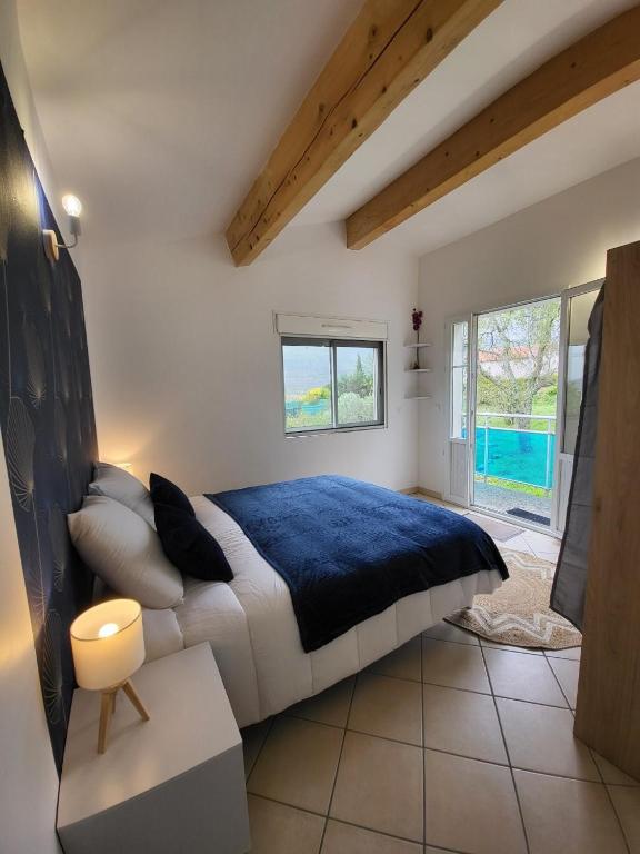 sypialnia z dużym łóżkiem i niebieskim kocem w obiekcie Nid douillet - LES FARGETTES - superbe vue - charmante petite maison avec jardin - 2 pièces à Privas w mieście Privas