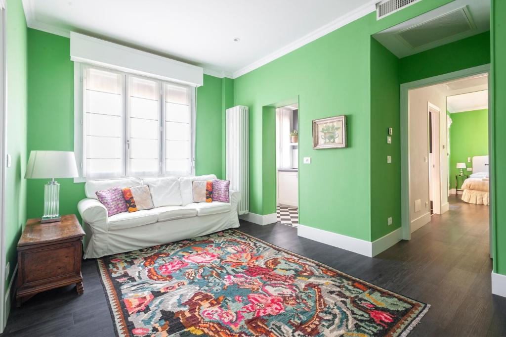 - un salon avec des murs verts et un canapé blanc dans l'établissement Green House city center, à Bologne