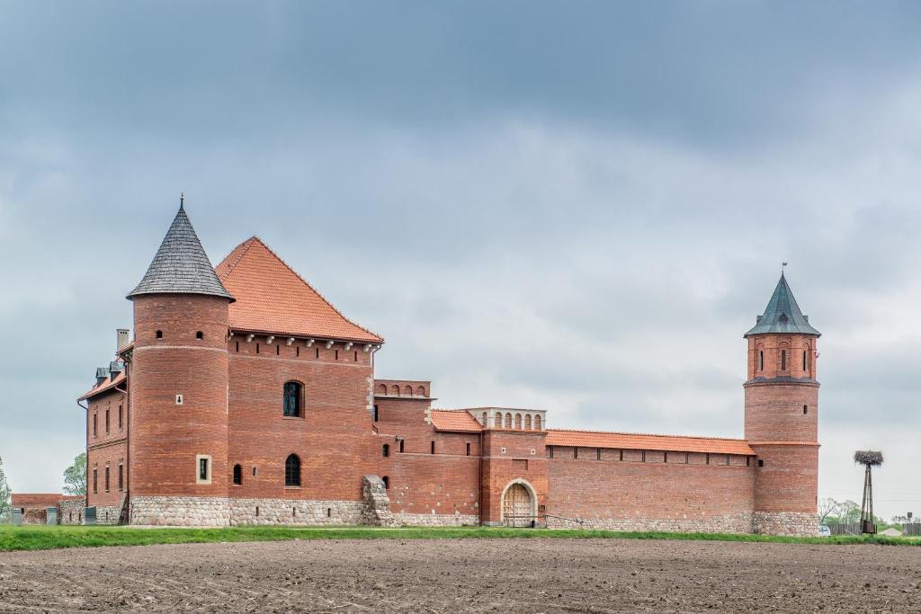 a large red brick building with two towers at Zamek w Tykocinie in Tykocin