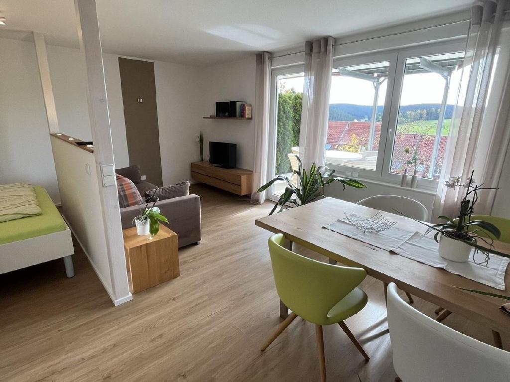 富特旺根的住宿－FeWo Furtwangen，一间带桌子的客厅和一间带沙发的房间