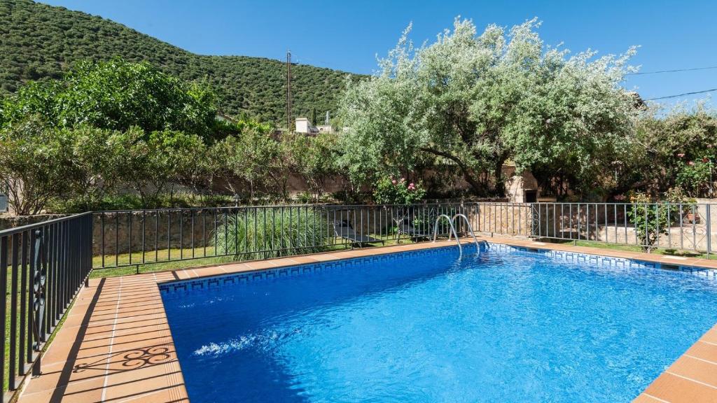 einen Pool in einem Garten mit einem Zaun und Bäumen in der Unterkunft Casa Rural La Ventilla Arbuniel by Ruralidays in Jaén