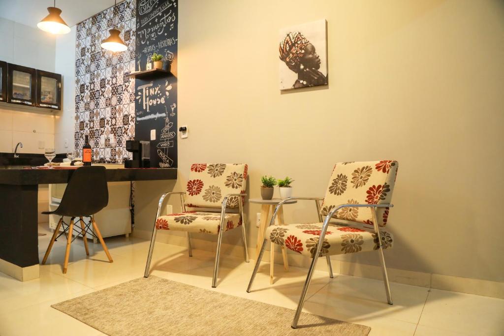 a kitchen with two chairs and a table and a counter at Casa Pequena, Completa e Aconchegante - Tiny House in Palmas