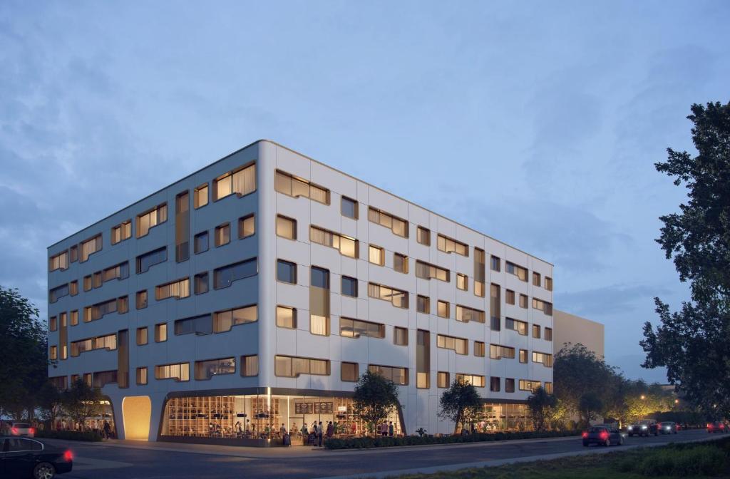 a large white building with lights on at Holiday Inn Express & Suites - Basel - Allschwil, an IHG Hotel in Basel