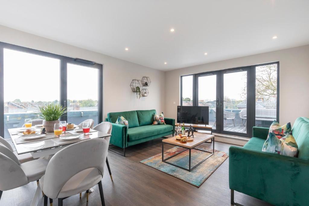 een woonkamer met groene meubels en een tafel bij Elliot Oliver - Stunning Three Bedroom Penthouse With Large Terrace & Parking in Gloucester