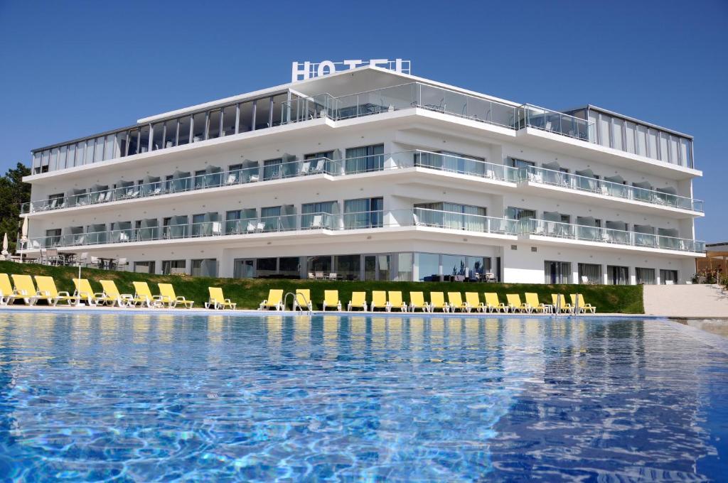 um hotel com piscina em frente a um edifício em Hotel Miramar Sul na Nazaré