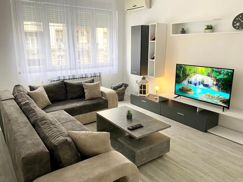 sala de estar con sofá y TV de pantalla plana en Grand Royal en Belgrado