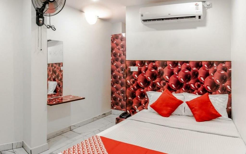 1 dormitorio con 1 cama con cabecero rojo en Amith Comforts, en Mysore