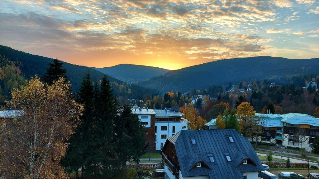 um pôr-do-sol sobre uma cidade com montanhas ao fundo em Apartments with mountain views em Špindlerŭv Mlýn