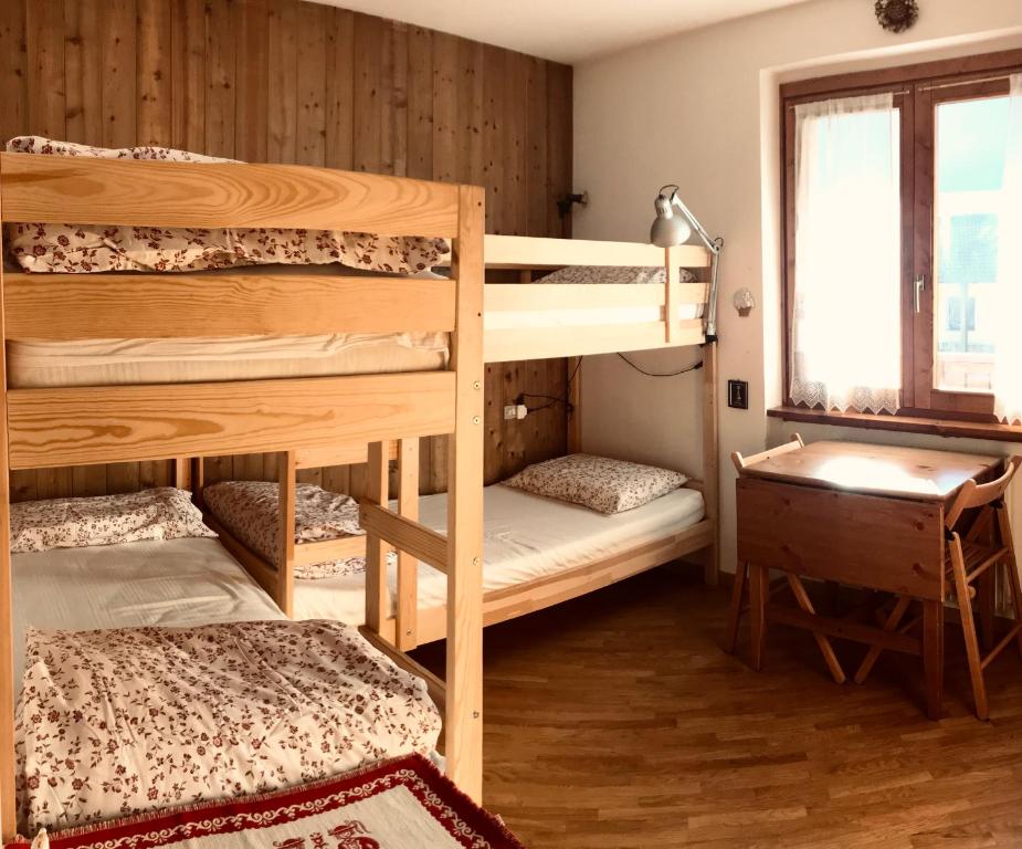 a room with two bunk beds and a desk at Appartamento Il nido in Carisolo