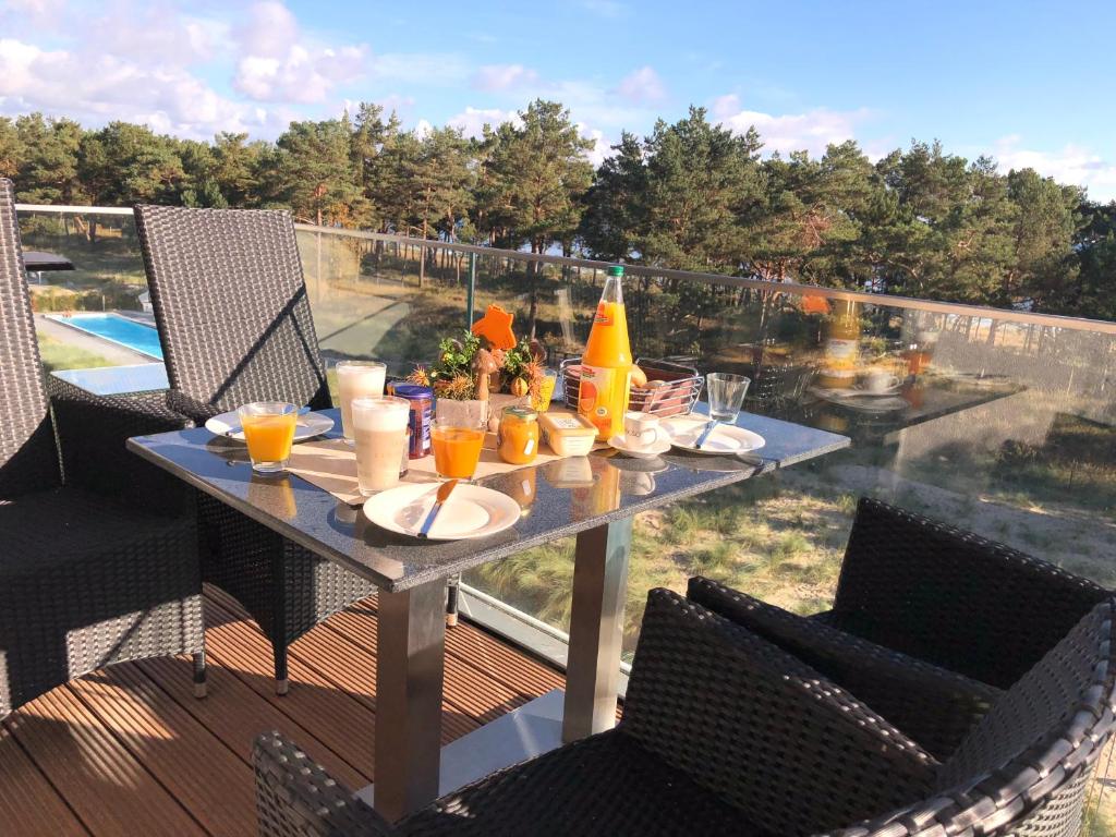 a table with food and drinks on a balcony at Avella "Sundowner" mit Meerblick, Innenpool und eigener Wallbox in Binz