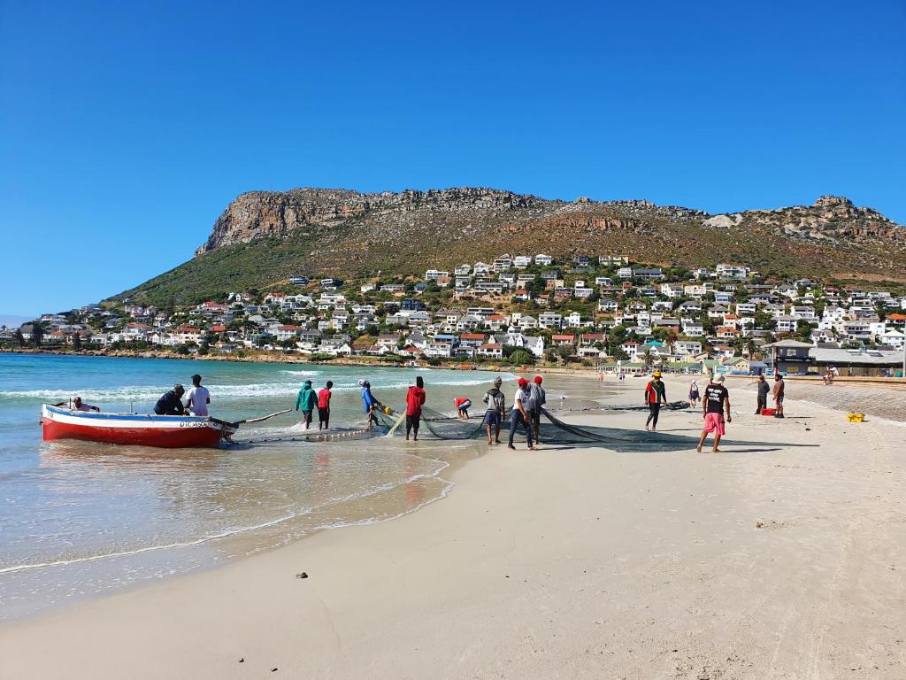 a group of people on a beach with a boat at Bob-Bob's Cottage in Cape Town