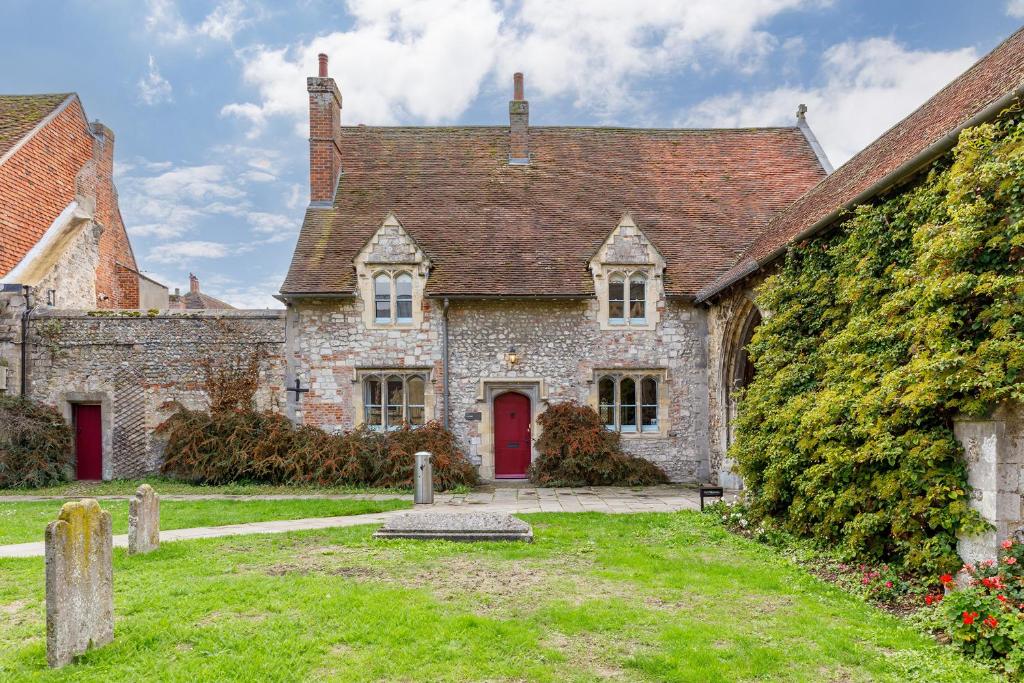 an old stone house with a red door at Cloisters Cottage in Chichester