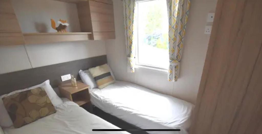a small room with a bed and a window at MV18 Park Holidays, St Osyth Beach no smoking self catering holiday in Saint Osyth