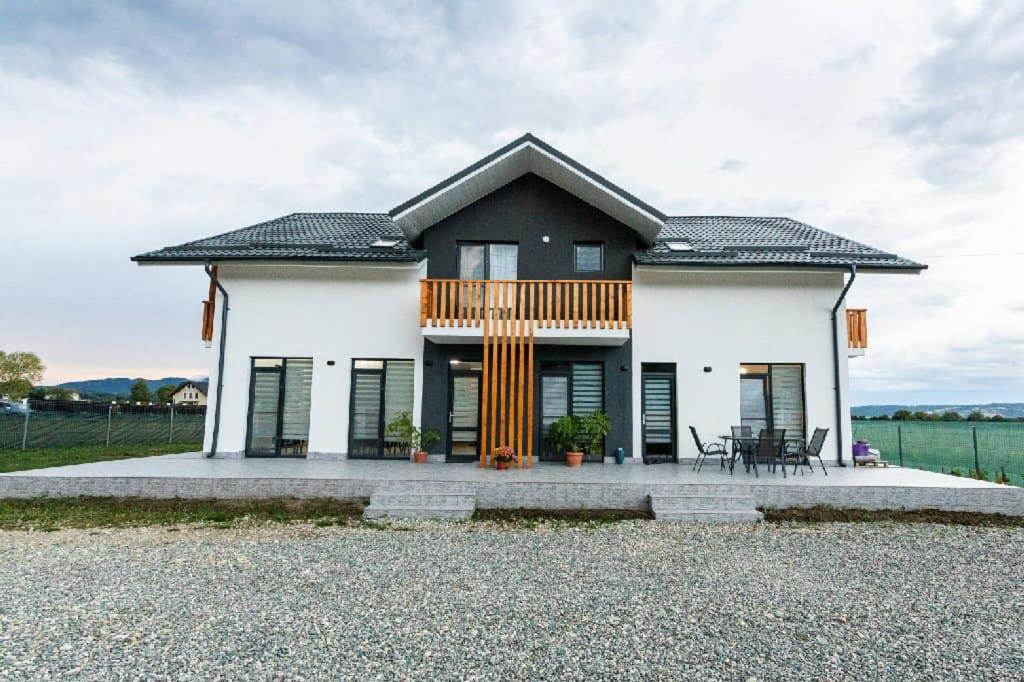 een wit huis met een zwart dak bij CASA VIKI in Bănicel