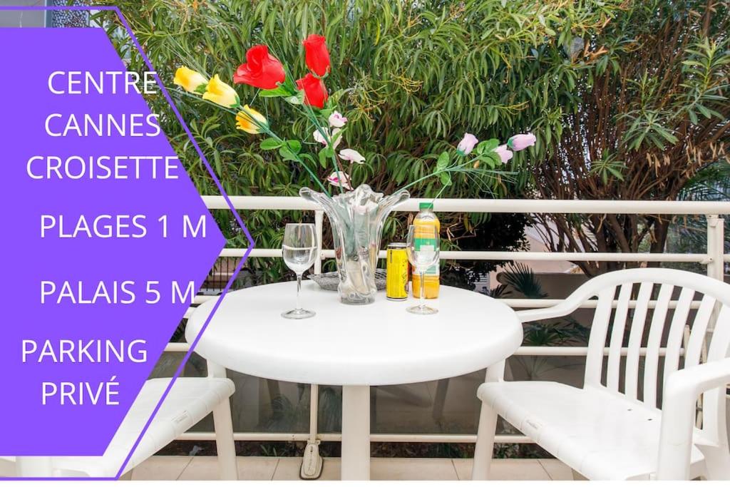 une table blanche avec un vase de fleurs et deux chaises dans l'établissement Perle Rare Cannes Centre Croisette Hôtel Carlton 1mn des Plages 5mn Palais, à Cannes
