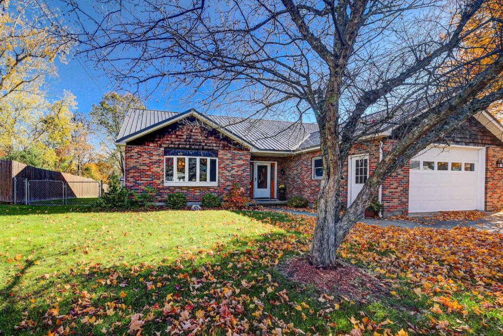 a brick house with a tree in the yard at House of Art Group Escape By Parks and Lake! in Winooski