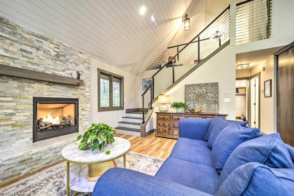ブレバードにあるChic Brevard Cabin - Nature, Trails, and Water!の青いソファと暖炉のあるリビングルーム