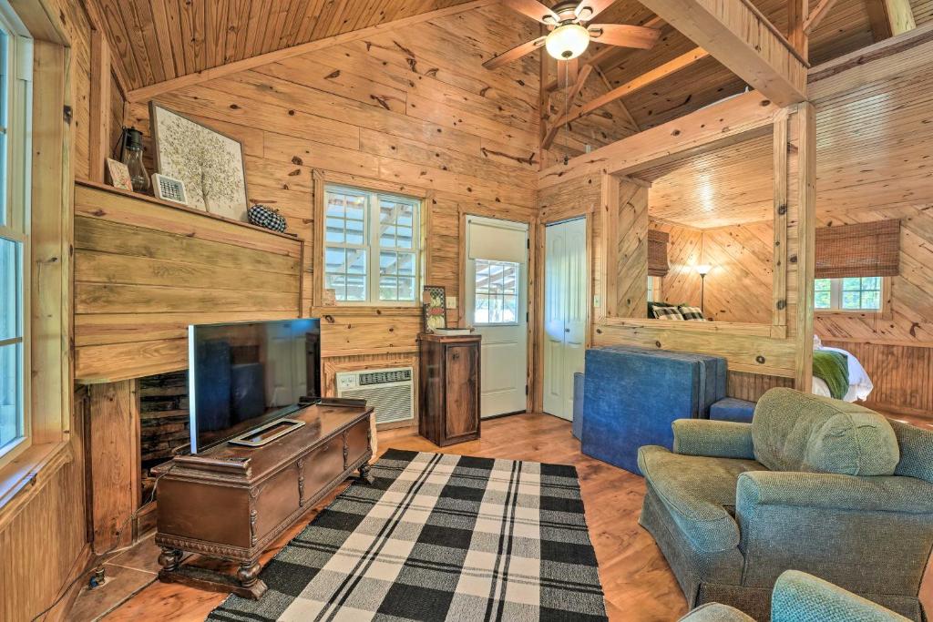 a living room with a tv and a couch at Idyllic Cabin with Fire Pit, Kayak On-Site! in Bells