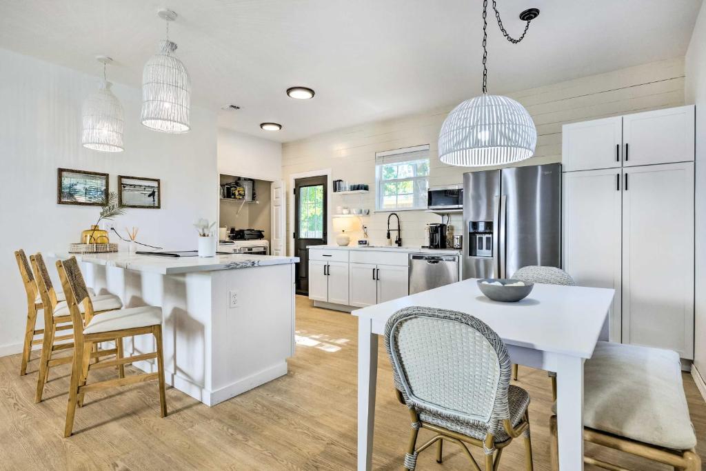 a kitchen with white cabinets and a table and chairs at Modern and Chic Gulfport Escape Walk to Beach! in Gulfport