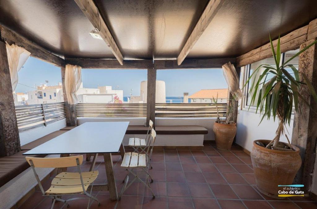 uma mesa e cadeiras numa varanda com vista em CASA ESCUELA PLAYA em San José