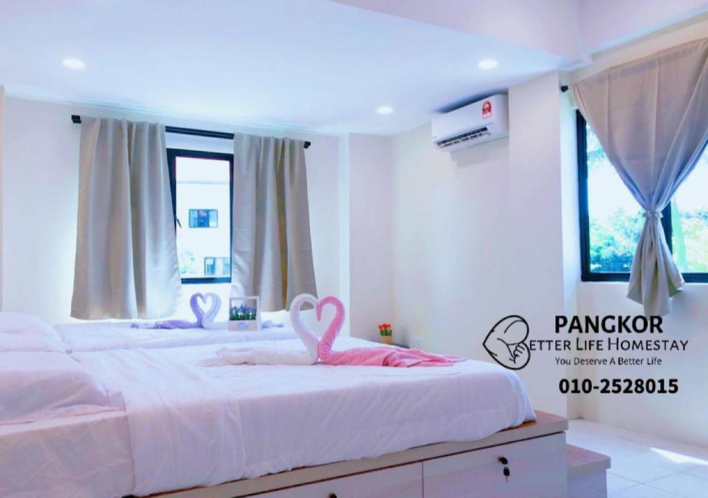 two beds with pink swans on them in a bedroom at Pangkor Pasir Bogak Apartment 2Rooms 2Bathrooms near beach 6pax FREE WIFI in Pangkor