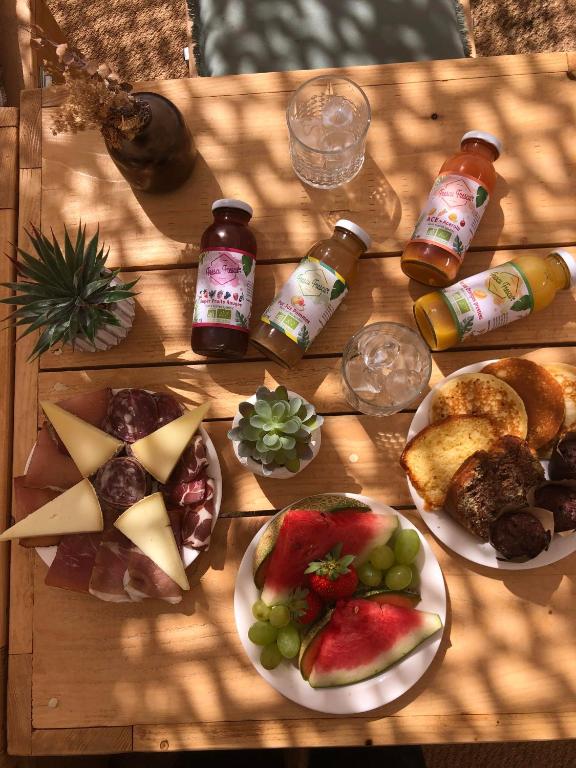 a wooden table topped with plates of food and drinks at Palm Beach in Ajaccio