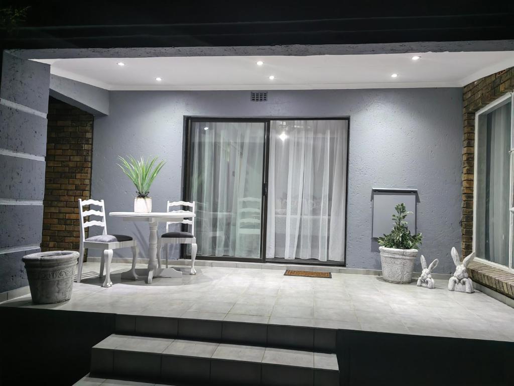 sala de estar con mesa y sillas en Zhantique Airport Guest House Unit 1 en Boksburg