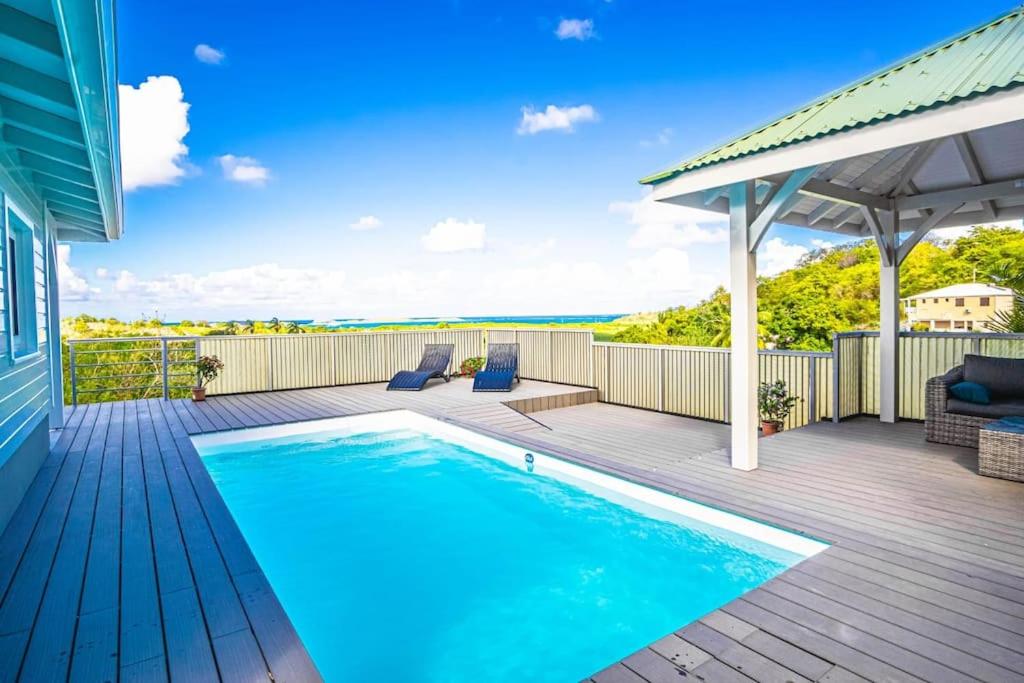 a swimming pool on the deck of a house at Magnifique villa piscine, vue mer, 8 km plages in Le François