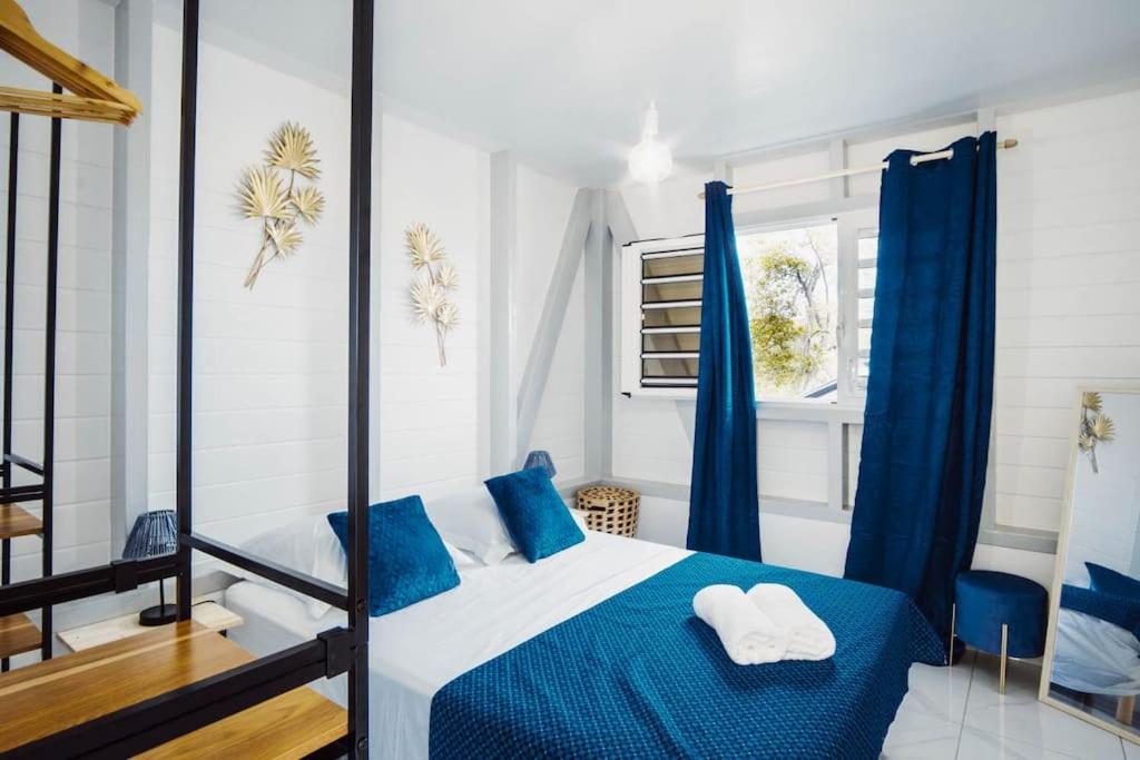 una camera da letto con un letto blu e bianco con cuscini blu di Magnifique villa piscine, vue mer, 8 km plages a Le François