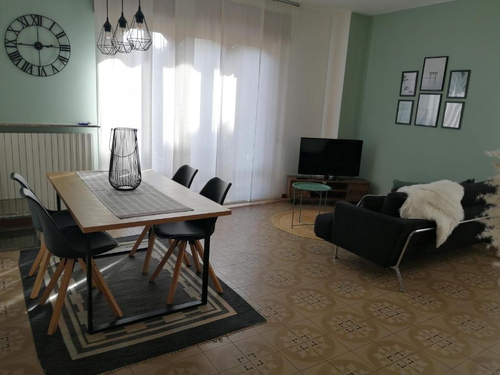een woonkamer met een tafel en stoelen en een bank bij Casa vacanze Donatella in Carenno