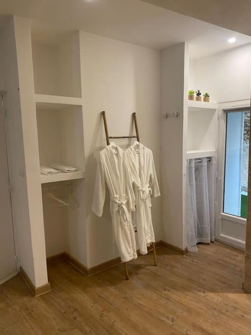a room with white shirts hanging on a wall at Superbe suite avec jacuzzi patio et sauna in La Ciotat