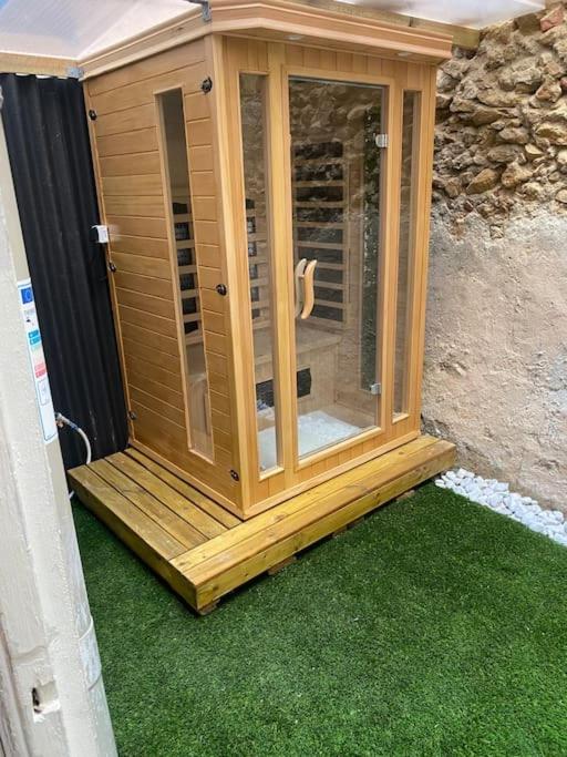 a wooden cabin sitting on some green grass at Superbe suite avec jacuzzi patio et sauna in La Ciotat