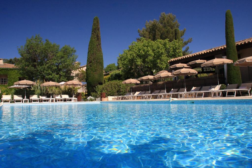 a large swimming pool with chairs and umbrellas at Hôtel De Mougins in Mougins