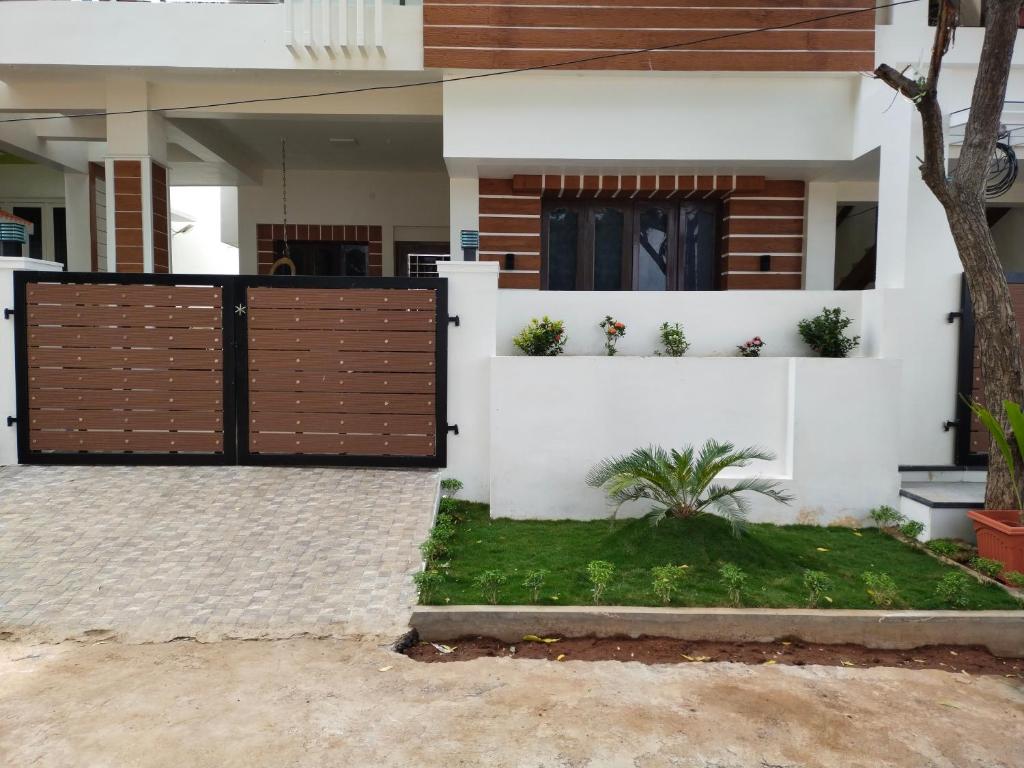 una casa con una puerta de madera delante de ella en Tirunelveli Home Stay, en Tirunelveli