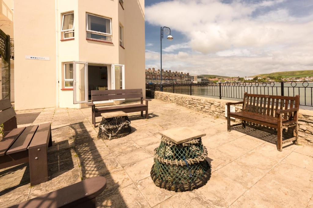 a patio with benches and a view of the water at 1 Quayside Court in Swanage