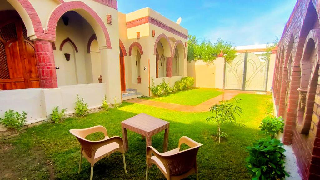 eine Terrasse mit Stühlen und einem Tisch im Hof in der Unterkunft Oriental house in Luxor