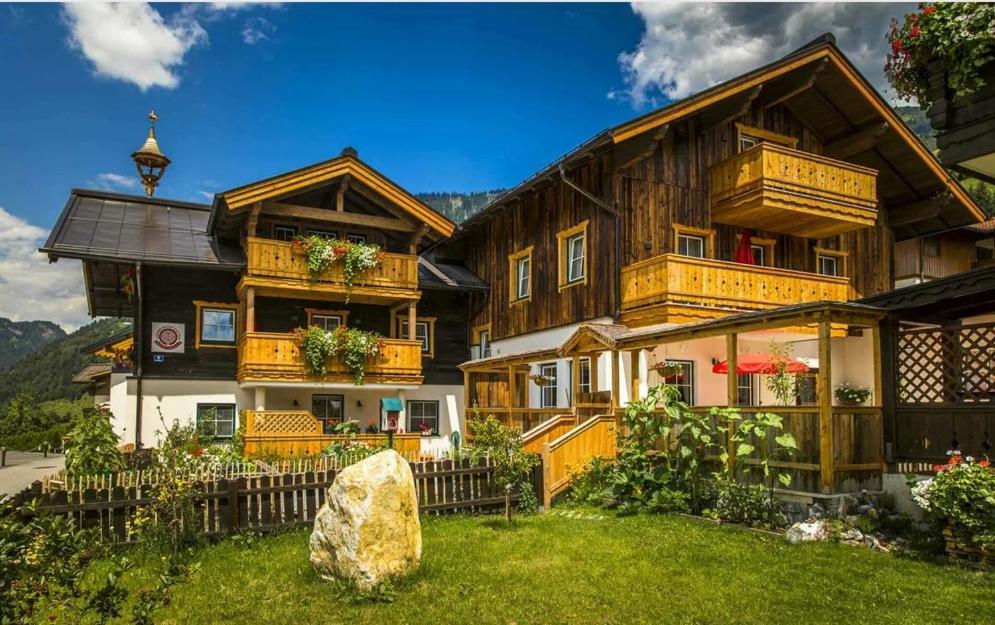 duży drewniany dom z kwiatami na oknach w obiekcie Anderlbauer w mieście Dorfgastein