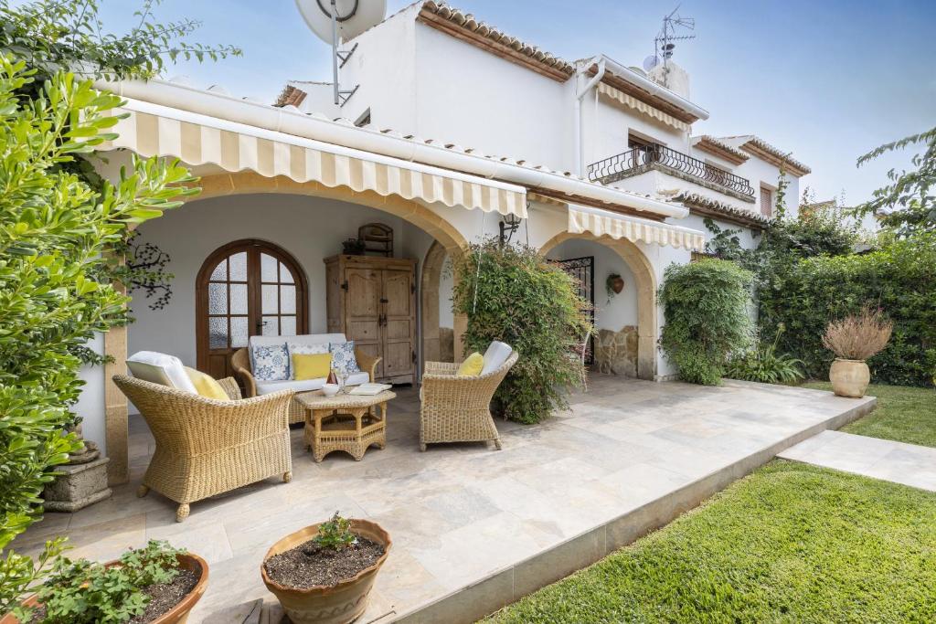 an outdoor patio with wicker chairs and a table at Casa Maya in Balcon del Mar