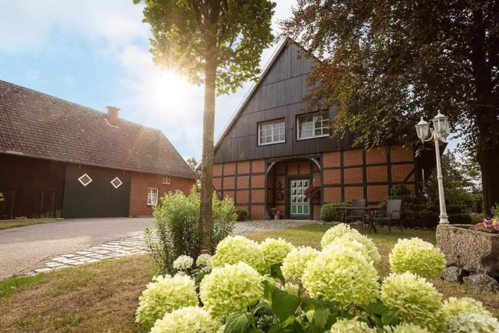 une maison avec un arbre et une cour avec des buissons dans l'établissement Herzlich Willkommen auf unserem Hof!, à Ladbergen