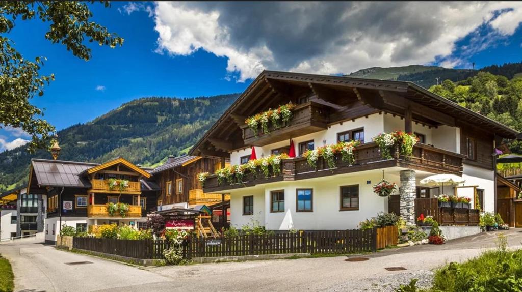 a house in the mountains with flowers on the balconies at Haus Kathrin in Dorfgastein