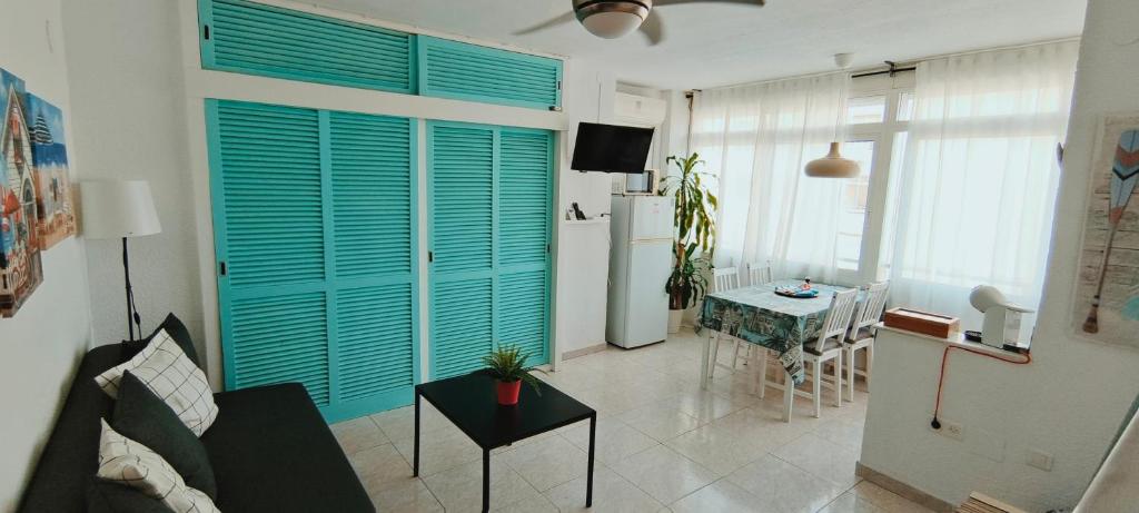 una sala de estar con una puerta de persianas azul en la cocina en J&H Apartment en Torremolinos
