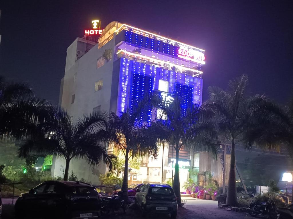 un edificio con luces azules por la noche en The Tripti Hotel & Banquets, en Indore