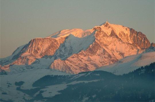 une montagne recouverte de neige avec le soleil brillant sur elle dans l'établissement Amethyste, à Saint-Gervais-les-Bains