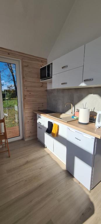 a kitchen with white cabinets and a counter top at Leon's Rooms in Żary