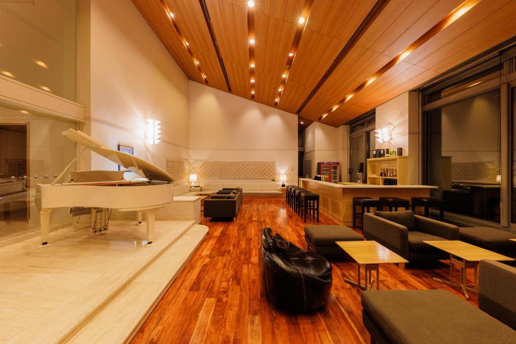 a living room with a piano and a couch and tables at 151 Hakuba by Jade Group in Hakuba