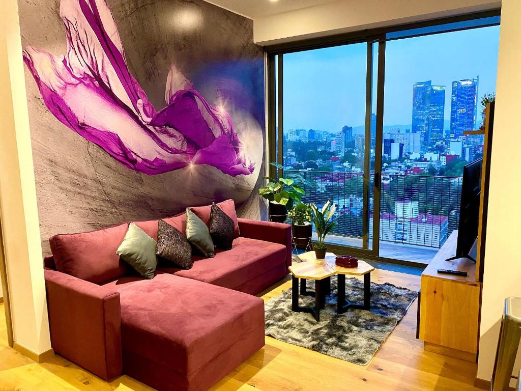 sala de estar con sofá rojo y ventana grande en Penthouse con la mejor vista de Cdmx, 6 personas, Gym y 2 parkings, en Ciudad de México