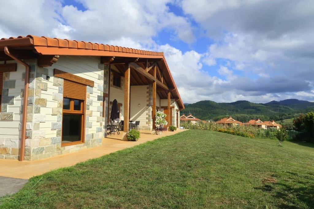 una pequeña casa de piedra con un patio de césped en Ven y disfruta en el corazón de Bizkaia-Urdaibai en Gautegiz Arteaga
