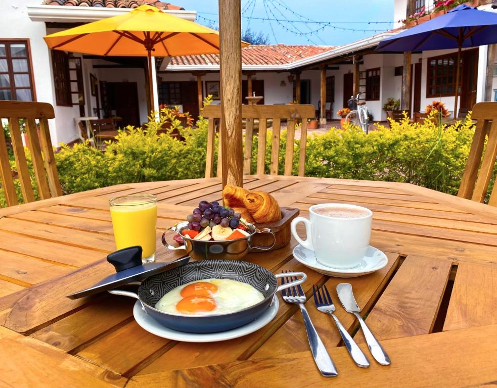 a breakfast of eggs and coffee on a wooden table at Hotel Evoque Sáchica in Villa de Leyva