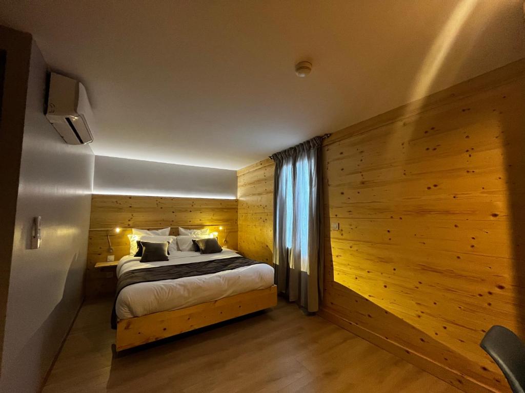 a bedroom with a bed and a wooden wall at 9WAGRAM Hotel Boutique in Le Mans