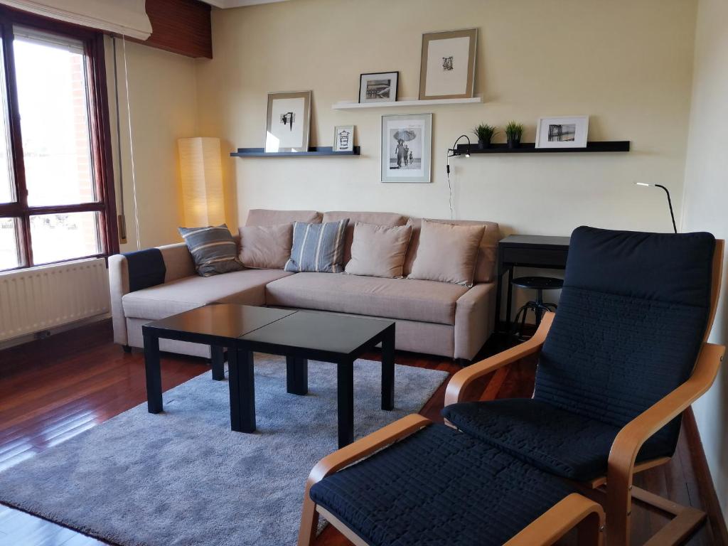 ein Wohnzimmer mit einem Sofa, einem Tisch und Stühlen in der Unterkunft Andramari Tourist Home Parking& wifi in Amorebieta-Etxano